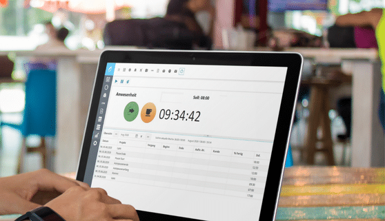 Ein Laptop zeigt eine Zeiterfassungssoftware mit laufender Uhrzeit und Projektübersicht auf dem Bildschirm.