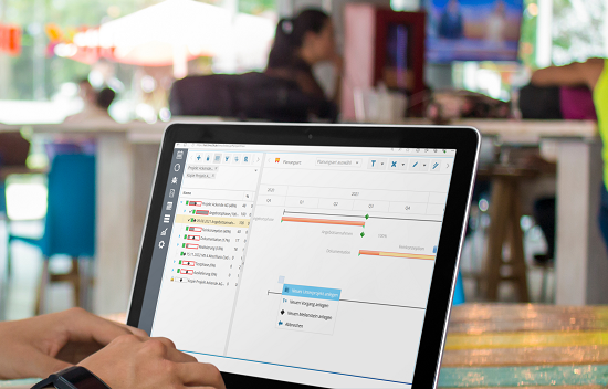 Die Ressourcenplanung-Software zeigt eine Gantt-Ansicht mit Aufgaben und Zeitplänen auf einem Laptop-Bildschirm.