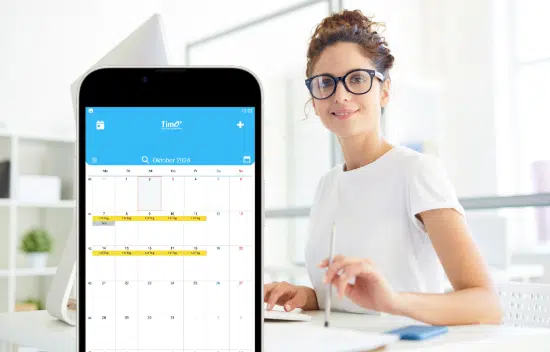 Projektmanagement-App mit Kalenderansicht auf einem Smartphone, gezeigt in einer Büroumgebung mit einer Frau am Arbeitsplatz.
