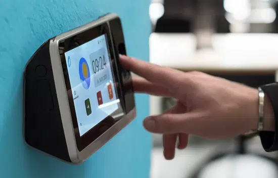 Fingerabdruckbasierte Zeiterfassung: Ein Mitarbeiter erfasst seine Arbeitszeit an einem Terminal.