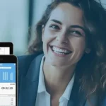 Die besten Zeiterfassungssysteme auf Monitor und Handy, während ein freundliches Gespräch im Business-Umfeld stattfindet.