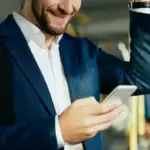 Mann in Business-Kleidung informiert sich während der Busfahrt über die pendlerpauschale 2026.